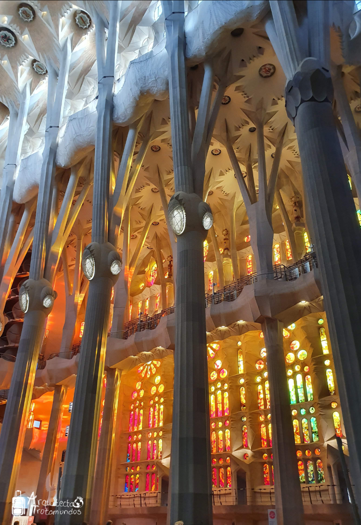 Luz del atardecer entrando por los vitrales de tonos cálidos de la Sagrada Familia.